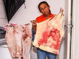 Avó mostra roupas claras manchadas de sangue; peças eram usadas durante socorro ao menino (Foto: Marcos Maluf)