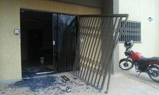 Porta de vidro do escritório foi arrebentada a tiros na madrugada de hoje (Foto: Leo Veras/Porã News)