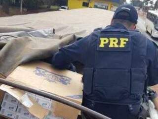 Policial confere caixas de cigarro contrabandeado em caminhão apreendido hoje (Foto: Divulgação)