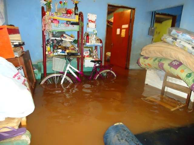 Forte chuva faz c&oacute;rrego transbordar e casas s&atilde;o inundadas em Dourados 