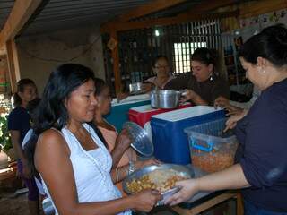 Moradores improvisam até com bacias recipientes para receber a alimentação. (Fotos: Paula Vitorino)