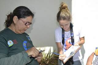 A fundadora do projeto passa as medidas do filhote para a bióloga de Belo Horizonte Daphne.