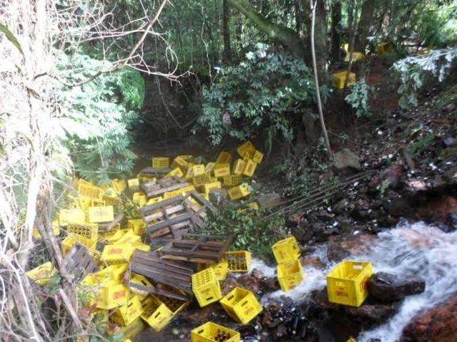 Carreta tomba e 30 mil garrafas de cerveja v&atilde;o parar dentro de c&oacute;rrego