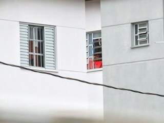 Alguém espia pela janela do apartamento do policial; PRF garante que ele voltou a trabalhar (Foto: André Bittar)