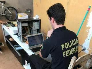 Policial federal pericia computador em local de buscas (Foto: PF/Divulgação)