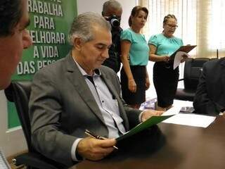 Governador Reinaldo Azambuja lê documento durante agenda nesta quarta-feira. (Foto: Kleber Clajus).