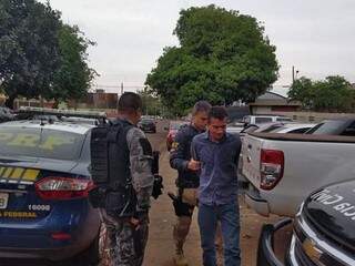 José Moura Matos é conduzido por policiais após ser preso com maconha na BR-463 (Foto: Adilson Domingos)