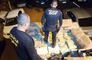Policiais retiram tabletes de maconha escondidos em carga de amido de milho (Foto: Divulgação)