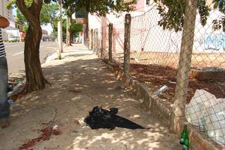 Na calçada do bar ficaram manchas de sangue e a camiseta da vítima. (Foto: Simão Nogueira)