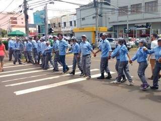 Trabalhadores fazem corrente na rua 14 de Julho. (Foto: Leonardo Rocha).