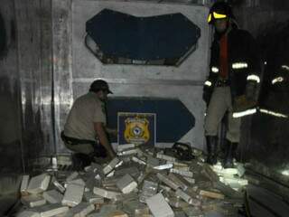 Policial e bombeiro dentro de contêiner com tabletes de cocaína (Foto: Divulgação/PRF)