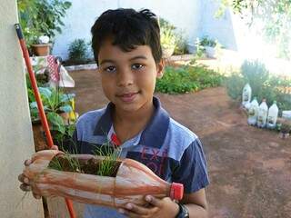 Matheus plantou cebolinhas e diz que vai ajudar a mãe no tempero do feijão. (Foto: Thailla Torres)