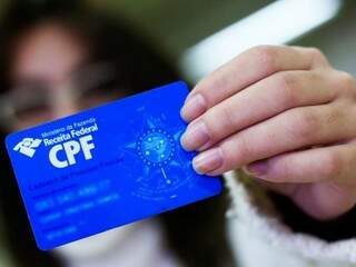 Mulher segurando um cartão de CPF. (Foto: Governo Federal) 