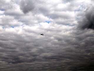 Avião em meio a nuvens carregadas, que se apresentaram no céu de Campo Grande neste 1º de agosto. (Foto: Saul Schramm)