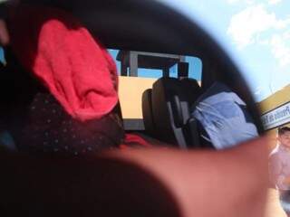 Detido esconde rosto com toalha vermelha dentro de van (Foto: Kísie Ainoã)