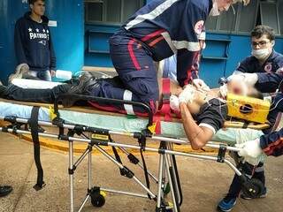 Socorrista do Samu tenta reanimar rapaz ferido a tiros hoje em Dourados (Foto: Adilson Domingos)