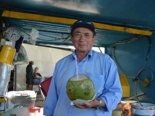 Carlito Barbosa oferece água de coco para as pessoas (Foto: Alana Portela)