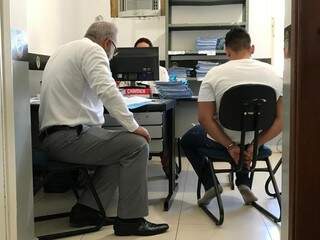 Ao lado do advogado, técnico de enfermagem presta esclarecimentos na Depca (Foto: Ronie Cruz)