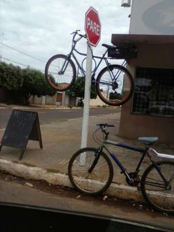 Bicicleta &eacute; presa sobre placa de PARE  no bairro Coophavila e gera curiosidade