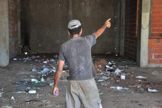 Um dos frequentadores da construção mostra ao Campo Grande News os cômodos do prédio. (Foto: João Garrigó)