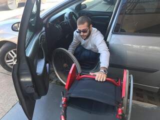 Lucas desmontando cadeira para colocá-la dentro do veículo. (Foto: Thailla Torres)