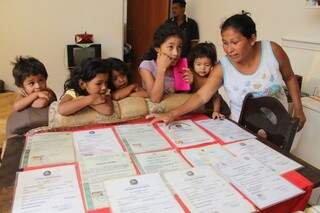 Rosana mostra as certidões de nascimento dos filhos e do neto (Foto: Marcos Ermínio)