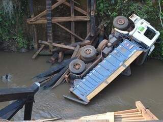 Caminhão estava carregado com cascalho e caiu dentro do rio Coxim (Foto: Coxim Agora)