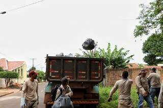 Saco de lixo no ar a caminho do caminhão durante coleta (Foto: Henrique Kawaminami)
