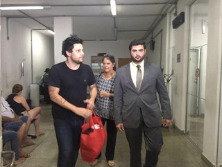 Cantor (de camisa preta) saindo da cadeia, junto a mãe e o advogado de defesa. (Foto: Camila Motta, do G1) 