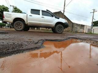 Veículo desvia de cratera na Rua Sargento Hércules Santos de Campos, no Bairro Coophasul. (Foto: André Bittar)
