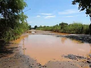 Lagoas de lama: rua sem asfalto em bairro deixa moradores ilhados