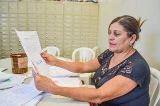 Maria Teodora dos Santos escolhendo as cartinhas para presentear a criançada. (Foto: Alana Portela)