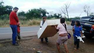 Índios carregam armário durante desocupação de fazenda em Dourados (Foto: Leomar Mariano/Facebook)