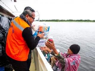 Homem ribeirinho recebe alimento da Defesa Civil (Foto: Divulgação)
