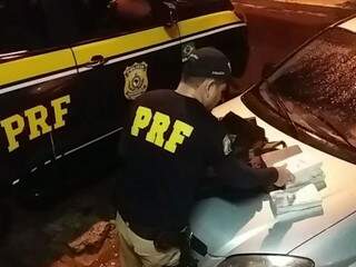 Policial separa tabletes de cocaína encontrados em guaiaca (Foto: Divulgação)
