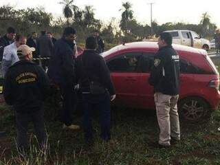 Policiais ao lado do carro ocupado por paraguaios mortos ontem em Pedro Juan Caballero (Foto: Porã News)