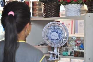 Comerciante improvisou ventiladorzinho em balcão do caixa para aguentar os dias quentes (Foto: João Garrigó)
