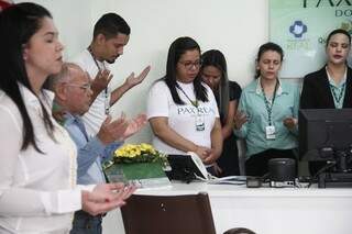 Raíssa (de camisa branca) em oração junto com os colegas de trabalho (Marcos Ermínio) 