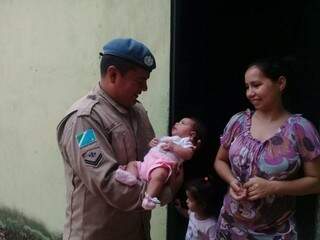 Cabo Gabriel Duran segura Mariana, de dois meses de idade, bebê que ajudou a salvar em Corumbá (Foto: Divulgação)