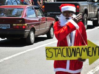 Homem vestido de Papai-Noel indica estacionamento particular no Centro. (Foto João Garrigó)