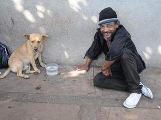 Morando na rua, Damião divide o pouco que tem com o melhor amigo de quatro patas (Foto: Paulo Francis)
