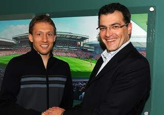 Lucas posa com diretor do Liverpool, Damien Comolli, após renovação de contrato. (Foto: Divulgação)