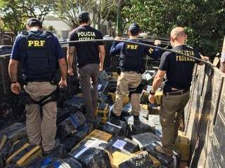 Policiais federais e rodoviários federais em meio a carga de maconha (Foto: Assessoria de Comunicação/ PF)