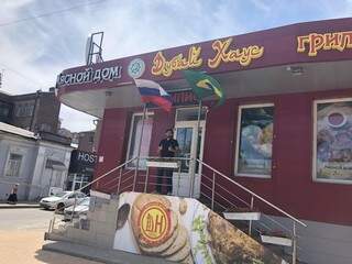 Na frente de restaurante, russo faz sinal de positivo aos gritos &quot;Brasil, Brasil, Brasil&quot; sob as bandeiras da Rússia e do Brasil (Foto: Paulo Nonato de Souza)