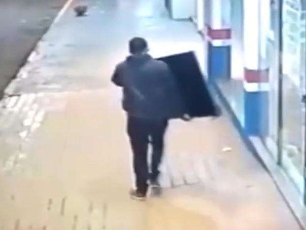 V&iacute;deo mostra ladr&atilde;o que arromba porta e sai tranquilamente pela rua com TVs