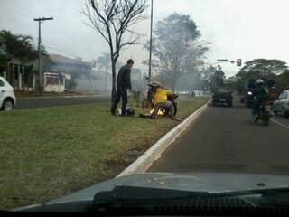 Motocicleta pega fogo na Via Parque e motoristas ajudam a apagar chamas