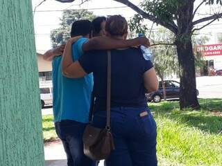 Pai (de camisa azul) saindo da delegacia, onde foi registrar o caso, amparado por amigos (Foto: Geisy Garnes) 