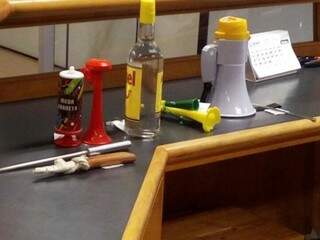 Buzina, faca, chaira e bebida na mesa, apreendidos na recepção da Assembleia. (Foto: Fausto Brites).