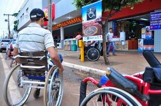 Cadeirantes saíram às ruas de Dourados hoje de manhã para protestar contra motoristas que ocupam vagas de deficientes em estacionamento (Foto: Eliel Oliveira)