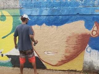 Voluntário grafitando o muro (Foto: Arquivo pessoal)
